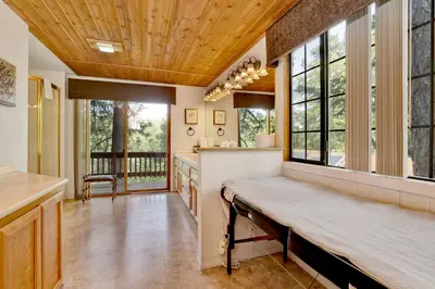 a large kitchen with a wooden ceiling and windows at Knickerbocker Retreat- Hot Tub- Game Tables in Big Bear Lake