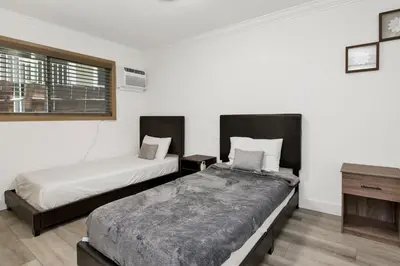 two beds in a room with white walls at Sweet Retreat 2- Cozy Relaxing Resort Cottage in Big Bear Lake