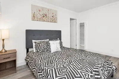 a bedroom with a bed with a black and white comforter at Sweet Retreat 2- Cozy Relaxing Resort Cottage in Big Bear Lake