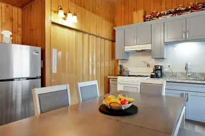 a kitchen with a table with a bowl of fruit on it at Sweet Retreat Combo- Relaxing Resort Cottage Combo in Big Bear Lake