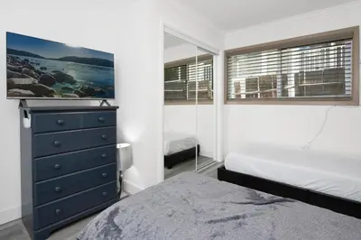 a bedroom with two beds and a dresser with a tv at Sweet Retreat Combo- Relaxing Resort Cottage Combo in Big Bear Lake