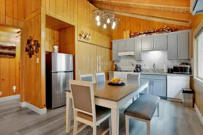 a kitchen with a table with chairs and a refrigerator at Sweet Retreat Combo- Relaxing Resort Cottage Combo in Big Bear Lake