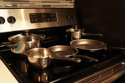 a stove with three pots and pans on it at Lux Oasis in West Hollywood, Free Parking & Swimming pool in Los Angeles