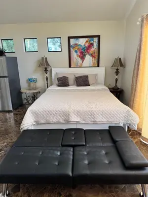 a bedroom with a bed with a black leather bench at Large Luxury Studio with View in Santa Monica in Santa Monica