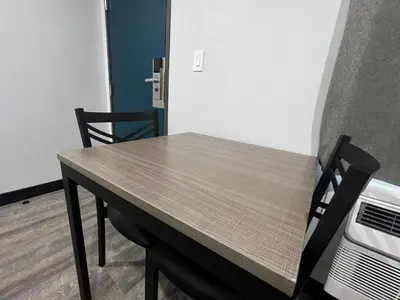 a table and chairs in a room with a wall at Vance Motel in Lynwood