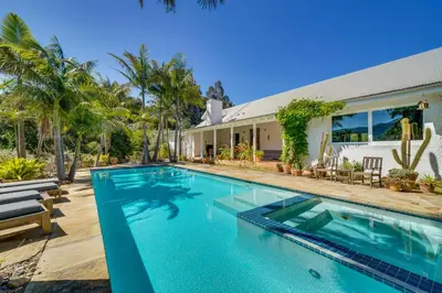 a swimming pool in front of a house at Farmhouse-Chic Carpinteria Cottage with Pool Access in Carpinteria
