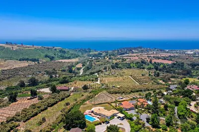 an aerial view of a estate with the ocean at Farmhouse-Chic Carpinteria Cottage with Pool Access in Carpinteria