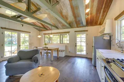 a kitchen and living room with a couch and a table at Farmhouse-Chic Carpinteria Cottage with Pool Access in Carpinteria