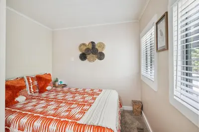 a bedroom with a bed with an orange and white comforter at Twin Peaks Vacation Rental with Hot Tub! in Twin Peaks