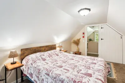 a bedroom with a large bed with a floral bedspread at Twin Peaks Vacation Rental with Hot Tub! in Twin Peaks