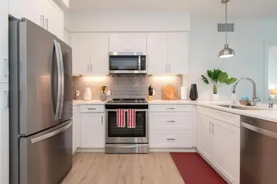 a kitchen with white cabinets and a stainless steel refrigerator at Comfy Apt with pool & hot tub in downtown LA 658 in Los Angeles