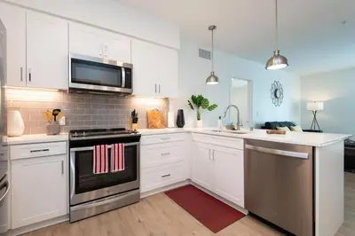 a kitchen with white cabinets and stainless steel appliances at Comfy Apt with pool & hot tub in downtown LA 658 in Los Angeles