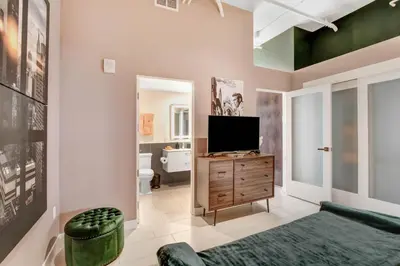a living room with a television on a wooden dresser at NYC Styled Loft In DTLA, sleeps 4 with Free Parking! in Los Angeles