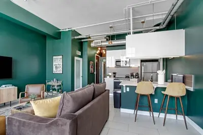 a living room with a couch and a kitchen at NYC Styled Loft In DTLA, sleeps 4 with Free Parking! in Los Angeles