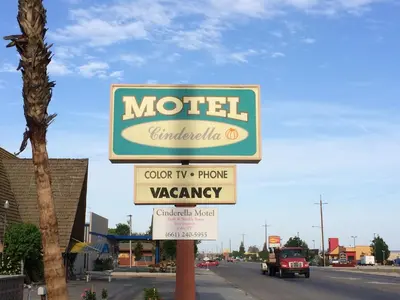 a sign for a motel on the side of a street at Cinderella Motel in Wasco
