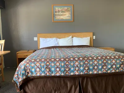 a bedroom with a bed with a colorful comforter at Cinderella Motel in Wasco