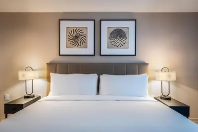 a bedroom with a large white bed with two lamps at Level Hollywood in Los Angeles