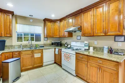 a kitchen with wooden cabinets and white appliances at Westminster Apartment Near Beaches and Theme Parks! in Westminster