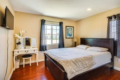 a bedroom with a bed and a desk with a mirror at Westminster Apartment Near Beaches and Theme Parks! in Westminster