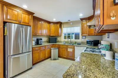 a kitchen with wooden cabinets and a stainless steel refrigerator at Westminster Apartment Near Beaches and Theme Parks! in Westminster