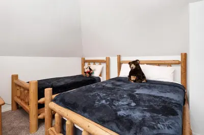two beds in a room with a dog sitting on them at Maltby Modern Log Cabin Relaxing Chalet Retreat in Big Bear Lake