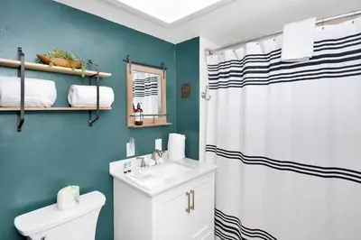a bathroom with a white shower curtain and a sink at Maltby Modern Log Cabin Relaxing Chalet Retreat in Big Bear Lake