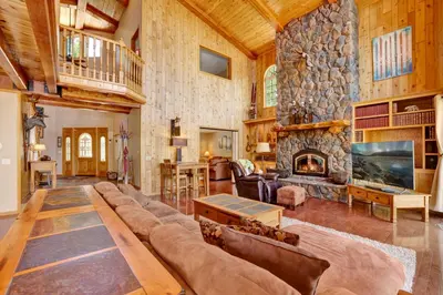a living room with a large stone fireplace at Lakefront Village Castle- Foosball- Boat Dock- in Big Bear Lake