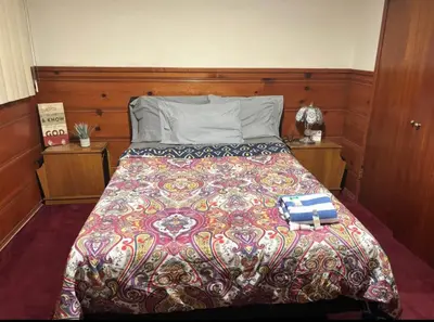 a bed with a colorful comforter and two books on it at Room in Monterey Park CA in Monterey Park