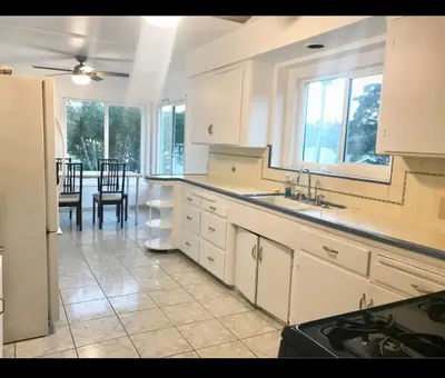 a kitchen with white cabinets and a dining room at Room in Monterey Park CA in Monterey Park