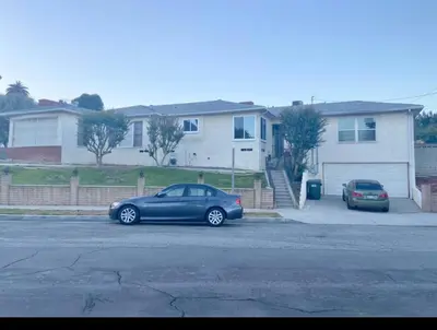 two cars parked in a parking lot in front of a house at Room in Monterey Park CA in Monterey Park