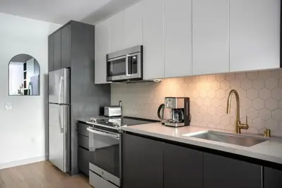 a kitchen with a sink and a stainless steel refrigerator at Hollywood studio w pool concierge nr shops LAX-1088 in Los Angeles