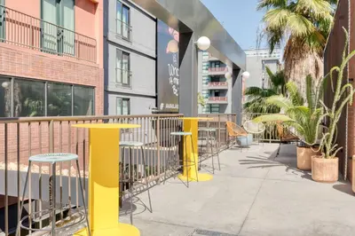 a sidewalk with tables and chairs in front of a building at Hollywood studio w pool concierge nr shops LAX-1088 in Los Angeles