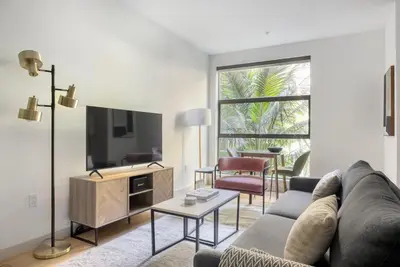 a living room with a couch and a tv at Hollywood studio w pool concierge nr shops LAX-1088 in Los Angeles