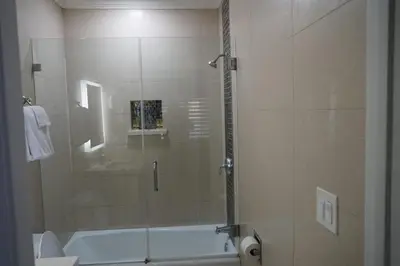 a bathroom with a shower with a glass door at Avenue Motel in Gardena