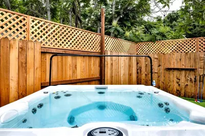 a hot tub in front of a wooden fence at Retro Cottage, Hot Tub, Putting Green, walk to all in Thousand Oaks