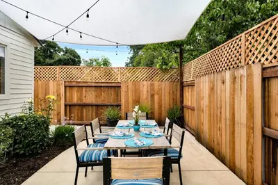 a patio with a table and chairs and a fence at Retro Cottage, Hot Tub, Putting Green, walk to all in Thousand Oaks