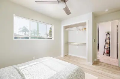 a white bedroom with a bed and a window at Cozy and Quiet Front House in Fontana