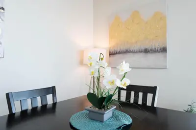 a table with a vase with white flowers on it at Spacious 3Bedroom Apt close to LAX & Sofi Stadium* in Los Angeles