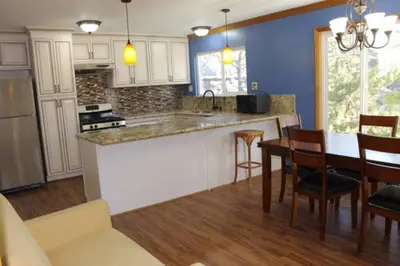 a kitchen with blue walls and a table and chairs at Beautiful Lake View House for rent! in Lake Arrowhead