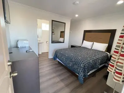 a hotel room with a bed and a bathroom at Palm Inn in Mojave