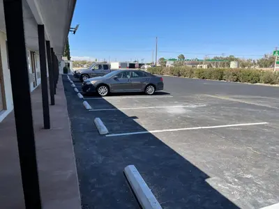 a car parked in a parking lot next to a building at Palm Inn in Mojave