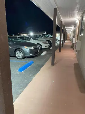 a row of parked cars in a parking lot at night at Palm Inn in Mojave