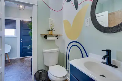 a bathroom with a toilet and a sink and a mirror at 1 Mi to Dtwn! Bright Long Beach Apartment in Long Beach