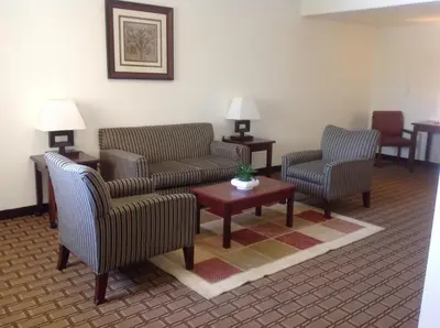 a waiting room with two chairs and a table at America Inn & Suites in Ridgecrest
