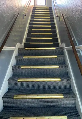 an escalator with gold steps in a building at Unity Hotel - No Parking & Rooms Are Upstairs in Long Beach