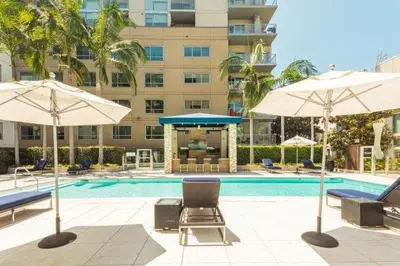 a swimming pool with two umbrellas and chairs and a swimming pool at Luxurious Hollywood Dream in Los Angeles