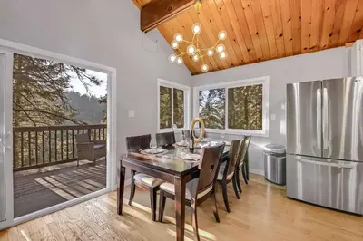 a dining room with a table and a refrigerator at Tree-Lined Lake Arrowhead Cabin about 1 Mi to Village! in Lake Arrowhead