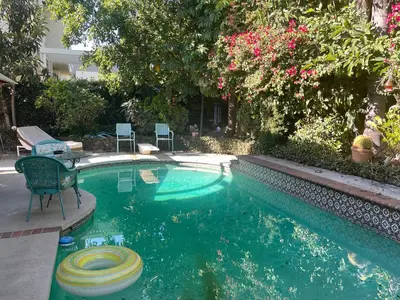 a swimming pool with a table and chairs in a yard at Ploy in Monterey Park