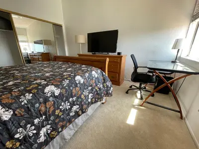 a hotel room with a bed and a desk and a television at Ploy in Monterey Park