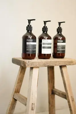 three bottles of soap sitting on top of a wooden stand at Modern Designer Cabin, Newly Renovated, EV Charger, Arcade, Kids Bunkbed, Minutes to Lake Arrowhead and Lake Gregory in Twin Peaks
